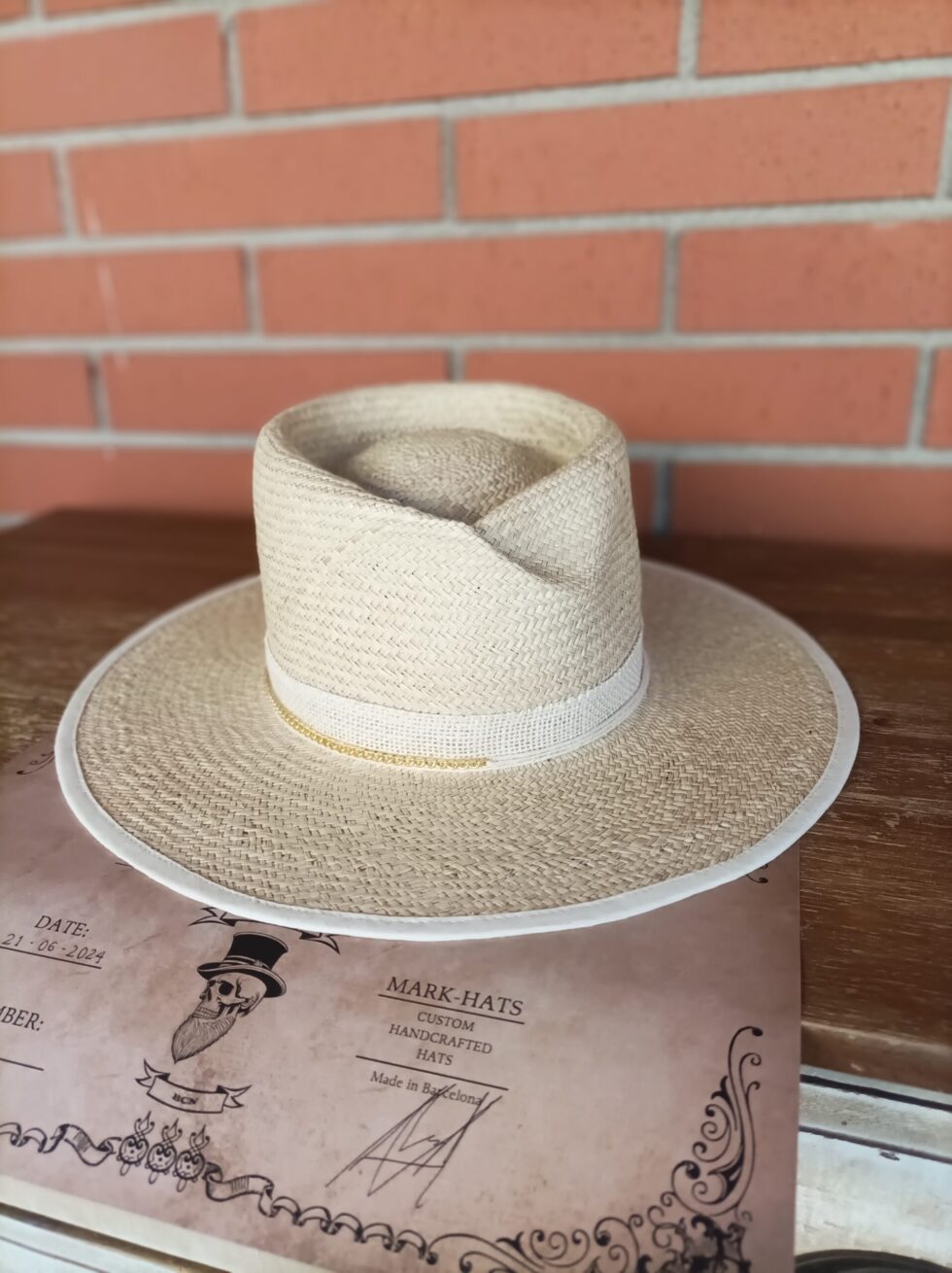 Professional handcrafted raffia straw hat with a signature pinch crown and a 10cm flat brim.