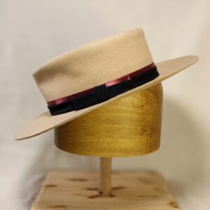 Hand-blocked sand wool felt hat with dual-tone black and burgundy grosgrain ribbon.